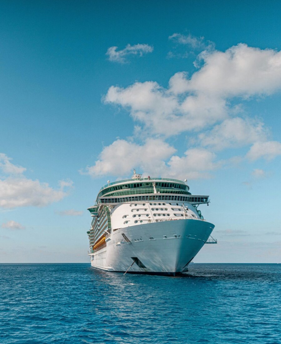 A cruise ship at anchor on open Caribbean water under a bright sky A cruise ship at anchor on open Caribbean water under a bright sky