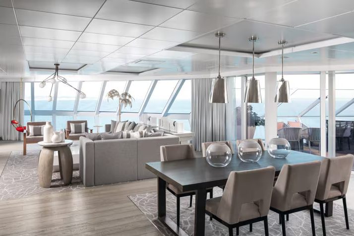 A Retreat suite living and dining room with floor-to-ceiling windows onto the sea A Retreat suite living and dining room with floor-to-ceiling windows onto the sea